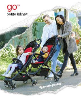 Familie mit zwei Kleinkindern, die in einem Park spazieren gehen und den go™ inline™  Buggy schieben