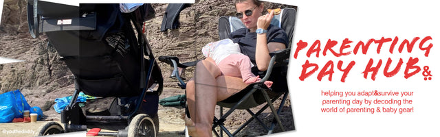 Mum sitting on a chair at the beach feeding baby with a 3 wheeled pushchair in the foreground - parenting day hub -  philandteds.com